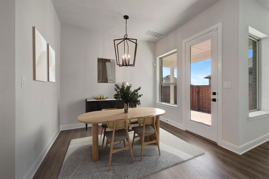 Dining room featuring dark wood-style floors and suspended lighting