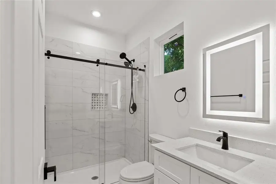 Bathroom featuring vanity and a marble finish shower