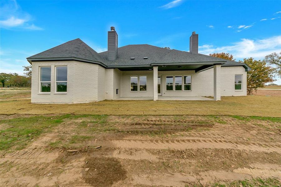 Back of property featuring a yard and a patio