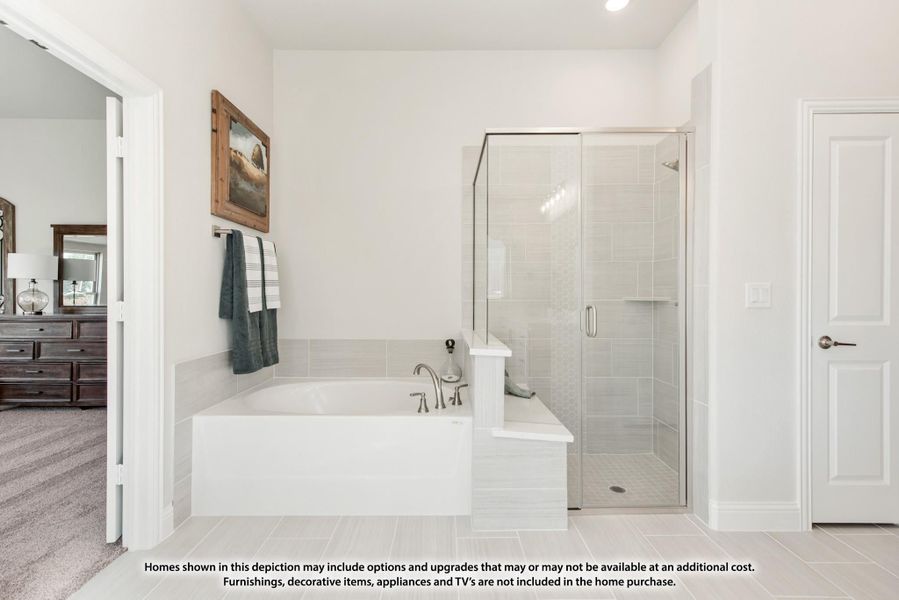 Master bathroom with soaking tub, glass-enclosed shower, and gray tile floors open to bedroom