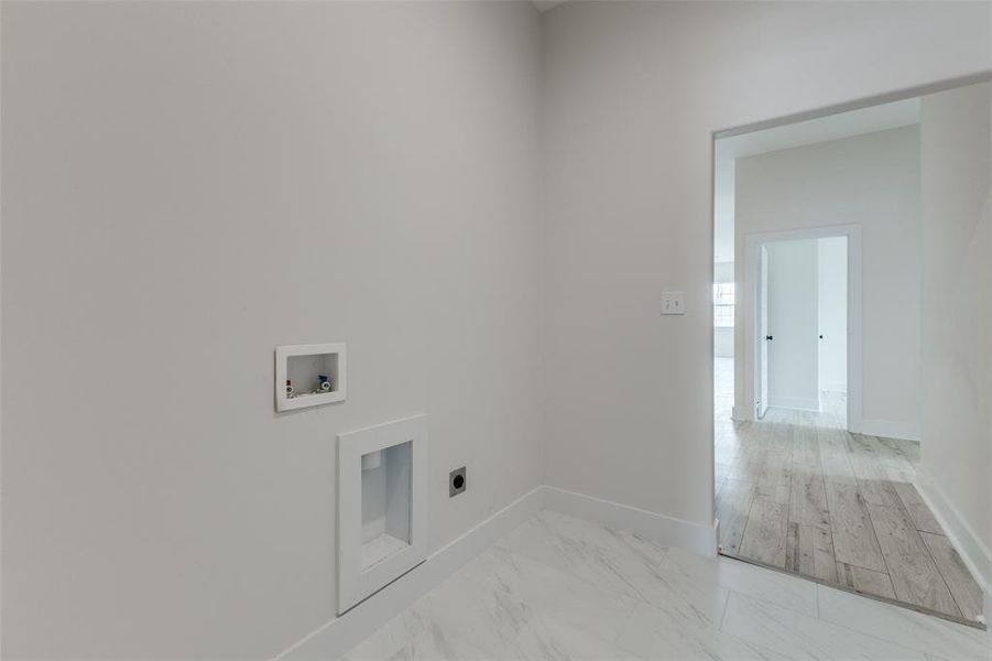 Laundry room with electric dryer hookup, baseboards, marble finish floor, and washer hookup