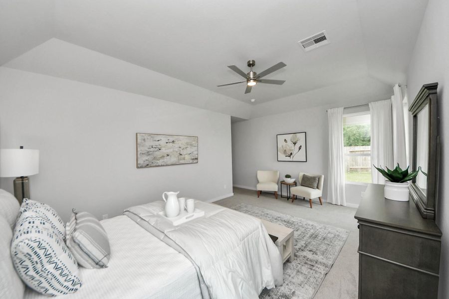 Escape and relax in the exquisite primary suite, a haven to unwind after a long day. The spacious room, located on first floor, boasts plush carpeting, soothing paint tones, high ceilings, and expansive windows adorned with privacy blinds. Sample photo of completed home with similar floor plan. Actual colors and selections may vary.