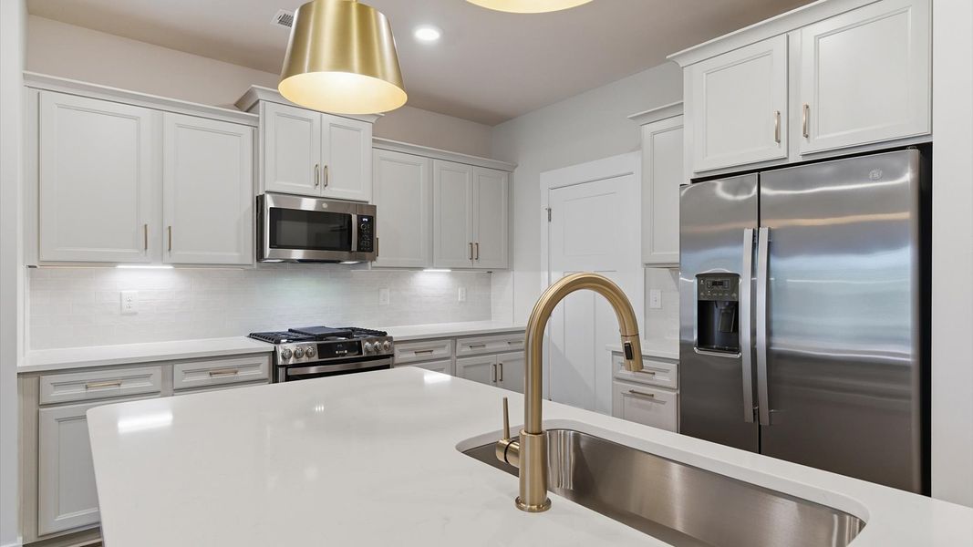 First-rate kitchen with functional layout, designer pendant lighting, and a large center island at Village at Midway First-rate kitchen with functional layout, designer pendant lighting, and a large center island at Village at Midway