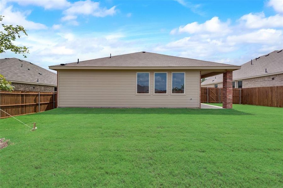 Back of property featuring a patio and a lawn