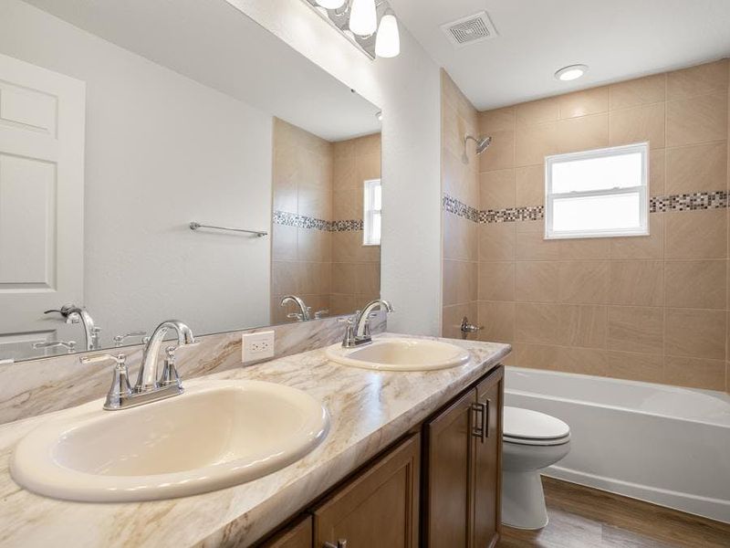 The secondary bedrooms share a dual-vanity hall bath.