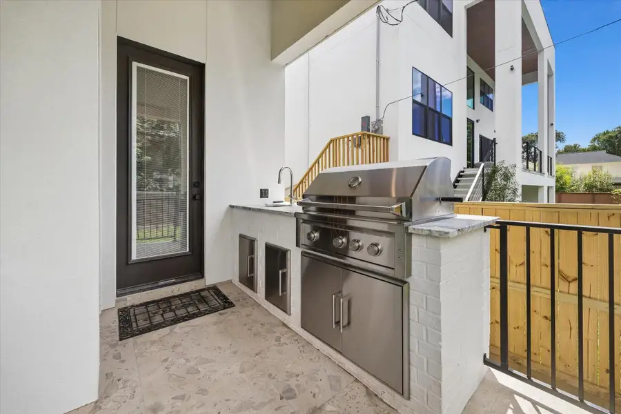 The covered summer kitchen features a built-in grill and prep sink, extending the home’s entertaining space to the backyard. The covered summer kitchen features a built-in grill and prep sink, extending the home’s entertaining space to the backyard.