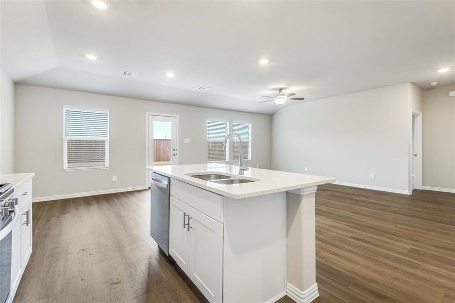 Kitchen with white cabinetry, recessed lighting, open floor plan, dark wood-type flooring, and light stone countertops