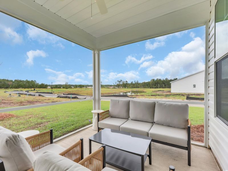 View of patio with an outdoor living space, ceiling fan, and a water view