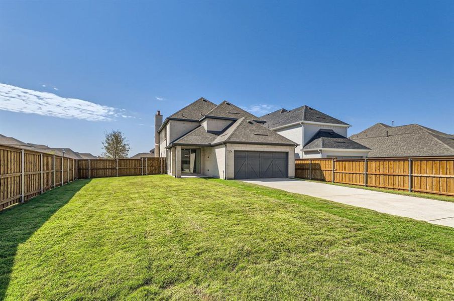 View of front of home with a front yard and a garage