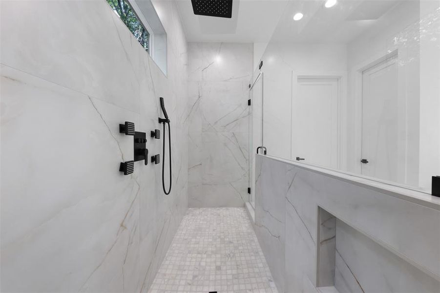 Bathroom with a marble finish shower and recessed lighting