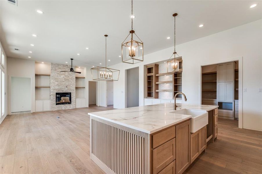 View of living and dining area from kitchen. Fireplace is stacked stone from floor to ceiling. View of living and dining area from kitchen. Fireplace is stacked stone from floor to ceiling.