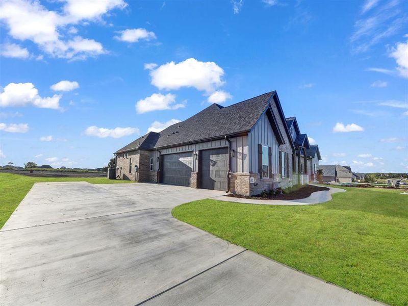 View of side of property with a garage and a yard