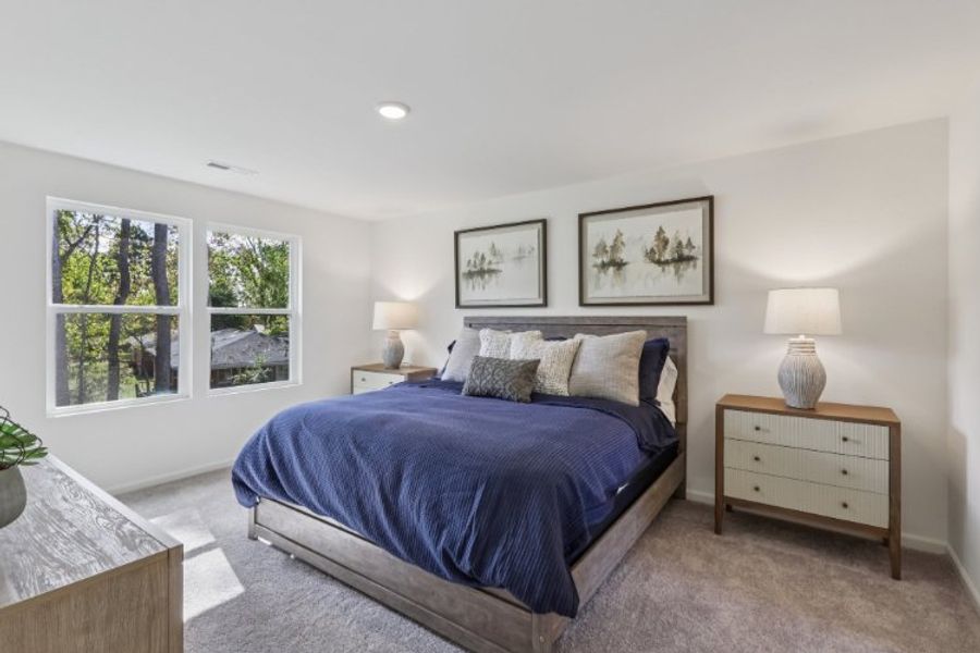 A bedroom with a bed and lamps.