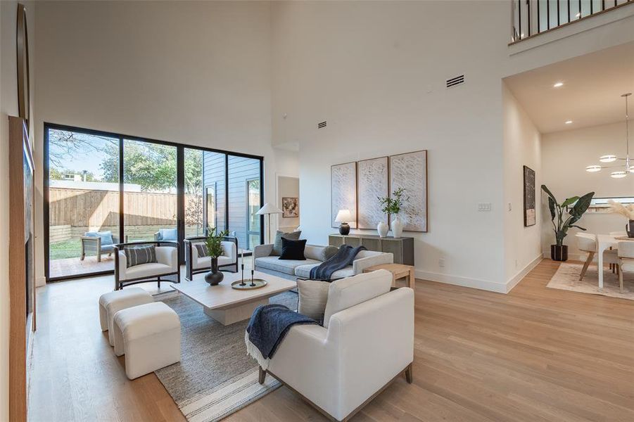 Living room featuring light hardwood / wood-style flooring and a high ceiling