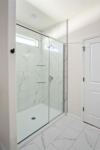 Primary ensuite with a tiled shower, tile flooring Primary ensuite with a tiled shower, tile flooring