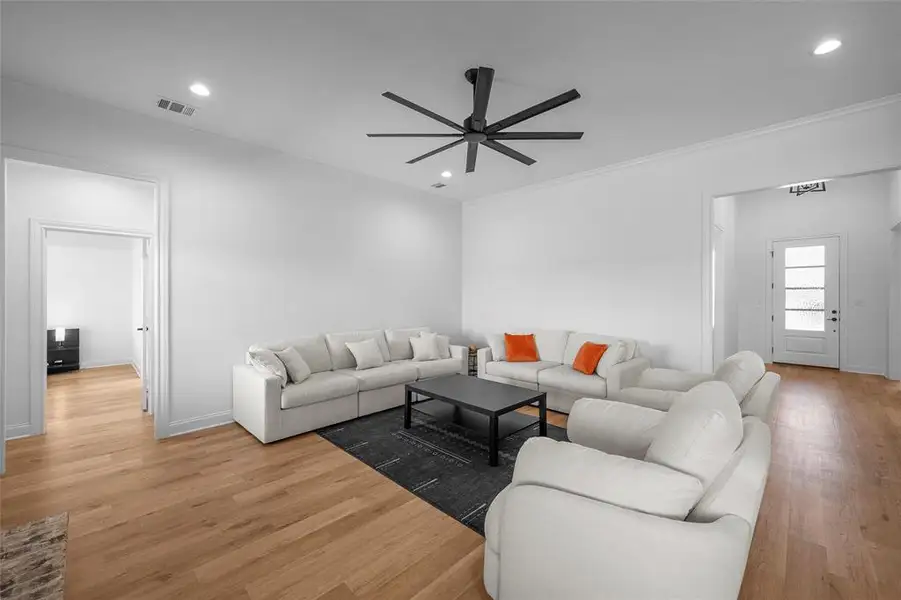 Living area featuring ornamental molding, light wood finished floors, a ceiling fan, and recessed lighting Living area featuring ornamental molding, light wood finished floors, a ceiling fan, and recessed lighting
