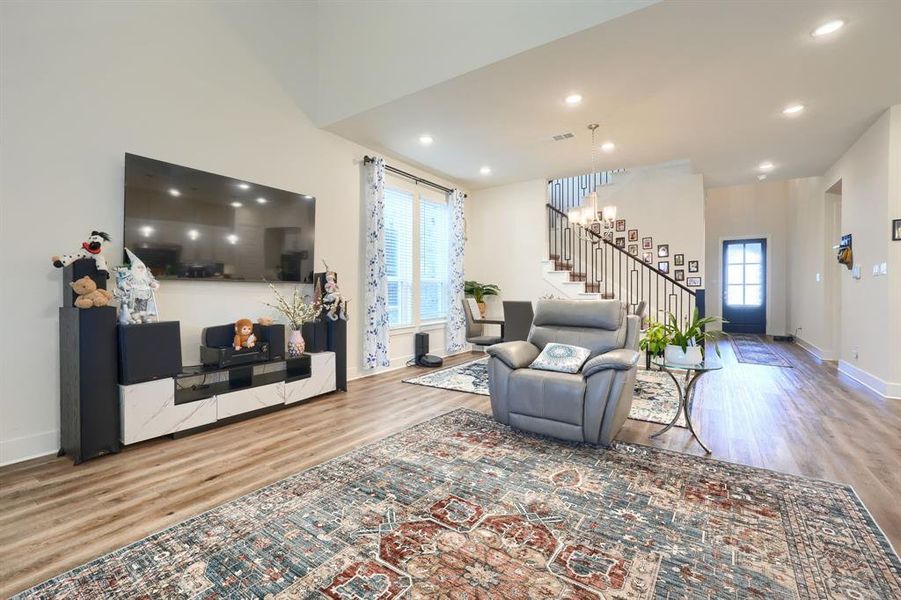 Living room with hardwood / wood-style floors, an inviting chandelier, and a wealth of natural light