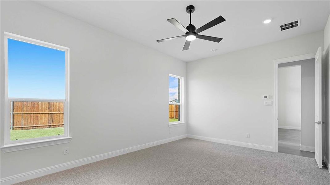 Carpeted empty room with ceiling fan and recessed lighting