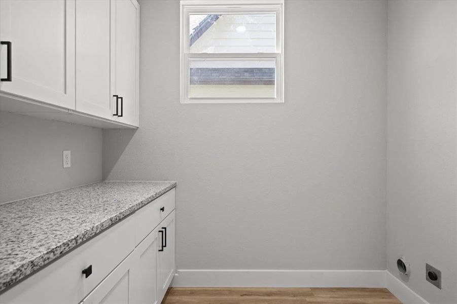 Laundry room featuring hookup for an electric dryer and light wood-type flooring