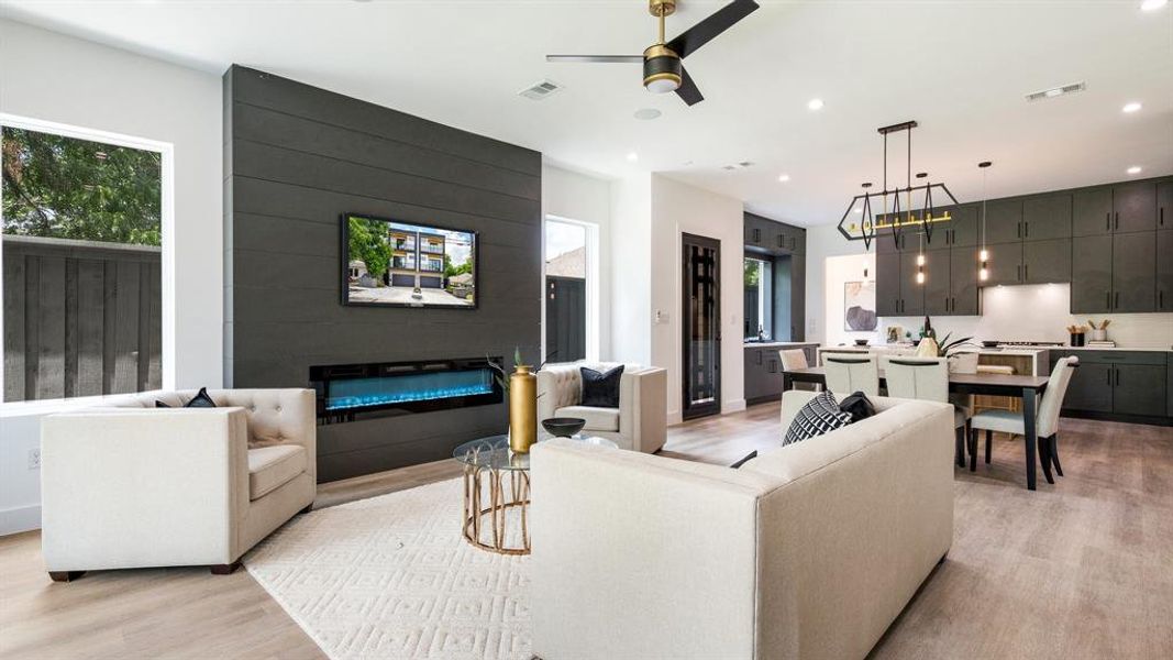 Living room with ceiling fan and light hardwood / wood-style flooring