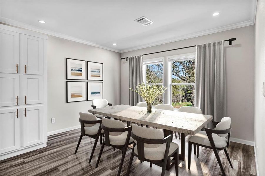 Dining space featuring crown molding, dark wood-type flooring, and recessed lighting