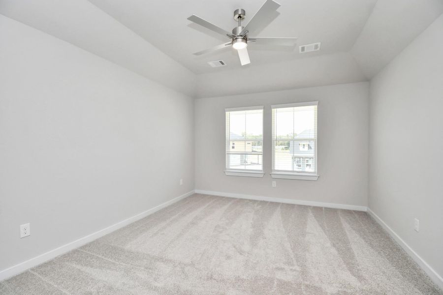 Secondary bedroom features plush carpeting, large windows that let in plenty of natural light, bright paint, and spacious closets.