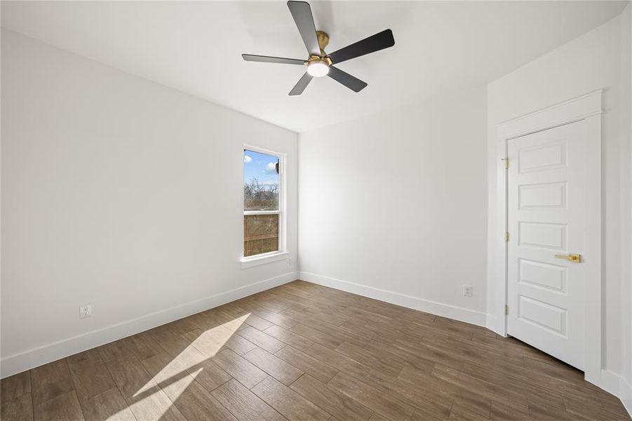 Empty room featuring dark wood-style floors and a ceiling fan