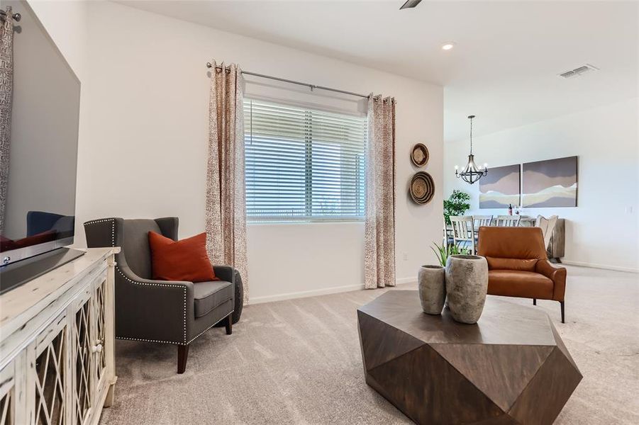 Sitting room with light colored carpet, recessed lighting, and a chandelier