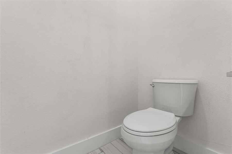 Bathroom featuring toilet and baseboards Bathroom featuring toilet and baseboards