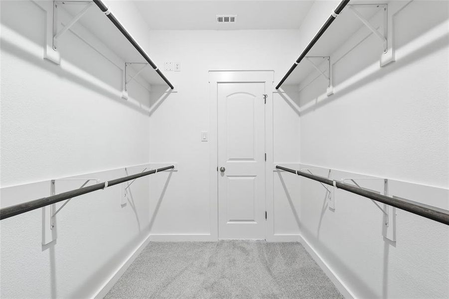 Spacious closet with light colored carpet Spacious closet with light colored carpet