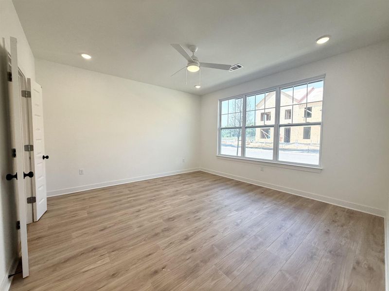Empty room featuring light wood finished floors, a ceiling fan, and recessed lighting