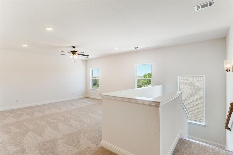 Unfurnished room featuring ceiling fan and light colored carpet