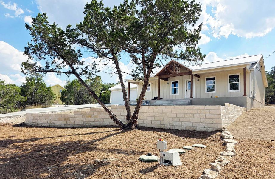 View of front facade with board and batten siding and a patio