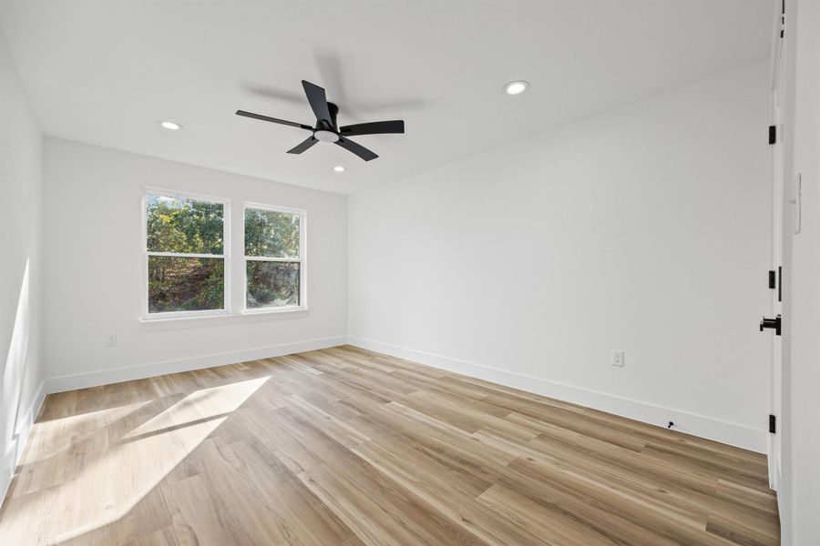 Secondary bedroom with light wood-type flooring, recessed lighting, and ceiling fan