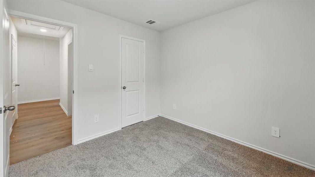 Unfurnished bedroom featuring baseboards and light carpet