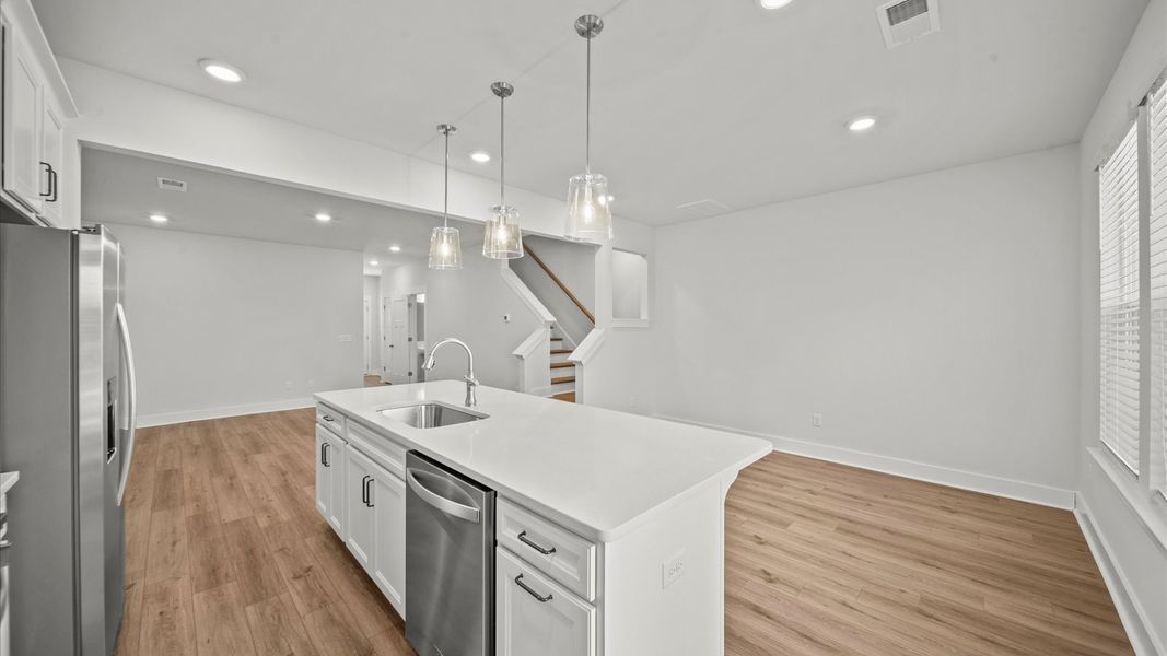 Exclusive DRB Homes kitchen with a 9-foot island, elevated finishes, and pendant lighting in a prime location