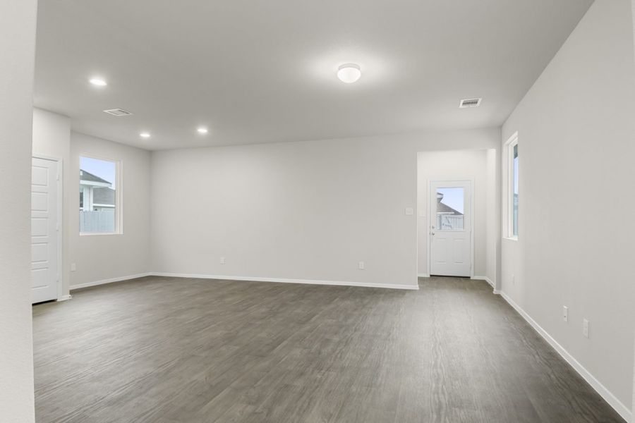 Image of a one story home living room with brown flooring and white walls