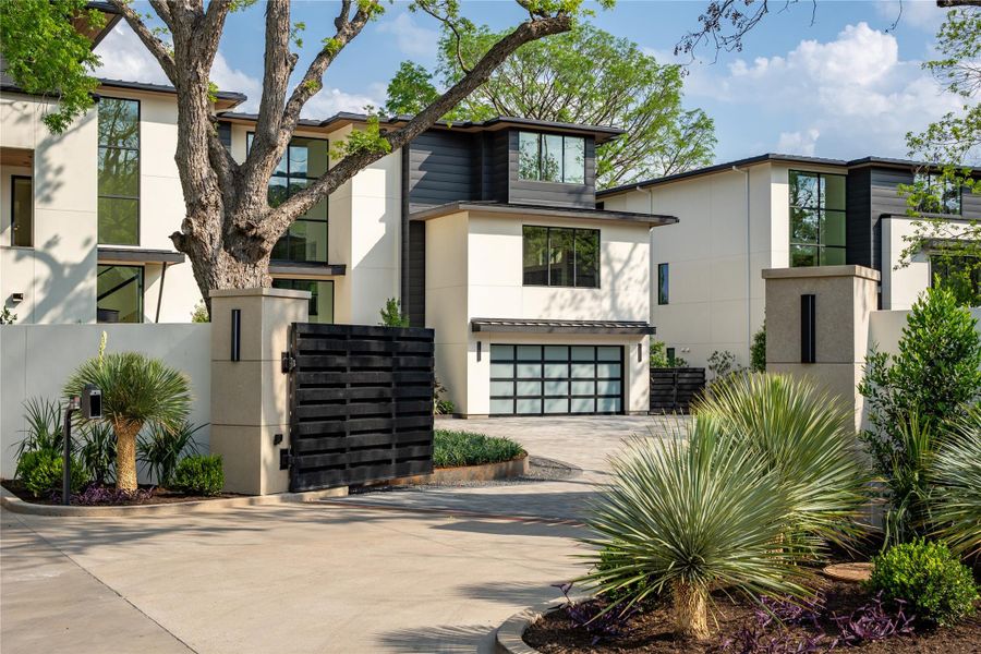 Contemporary house featuring stucco siding, decorative driveway, and an attached garage