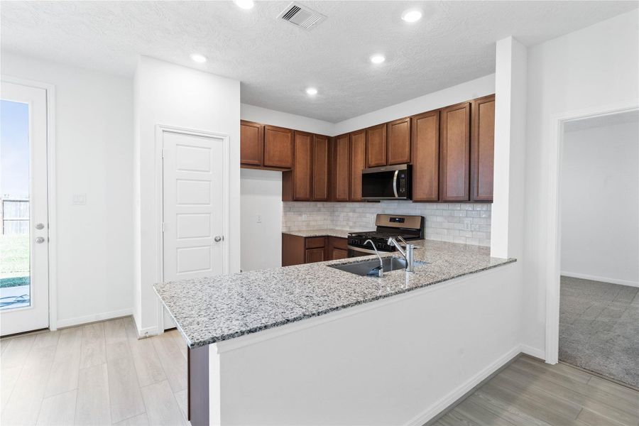 This spacious kitchen has it all—ample storage, generous counter space, and a layout that truly makes it the heart of the home.