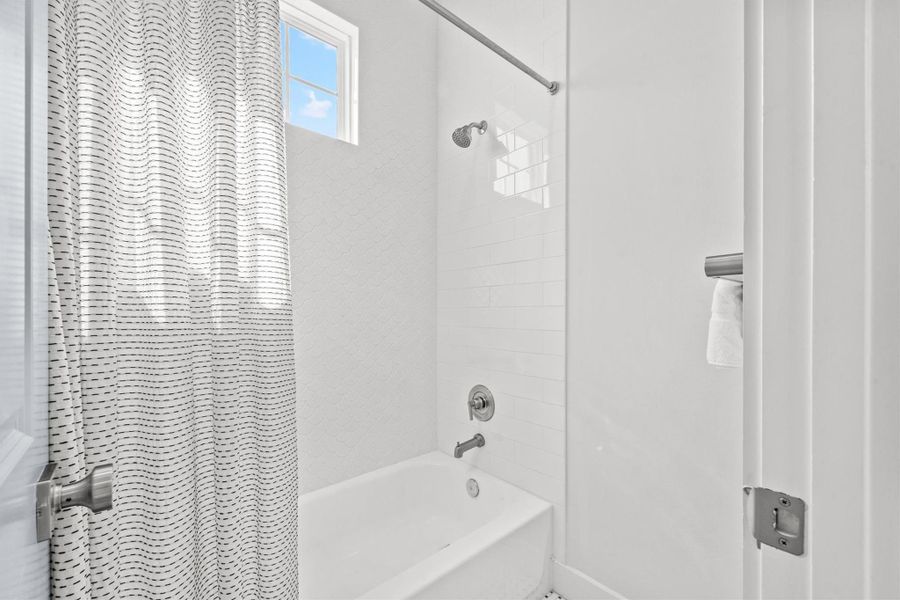 The shared second-floor bathroom features a tub-shower combination, accented by beautiful tile.