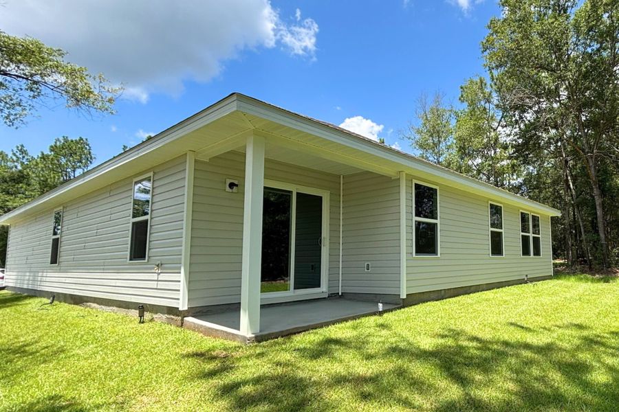A white house with a lawn.