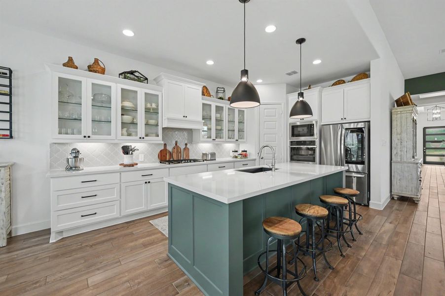 This large island easily seats four and is the perfect spot for a quick meal on the go! The island was painted an accent color and the quartz counter tops and backsplash were an upgrade. The seller added the glass front cabinets and pull out drawers for convenience plus a built-in trash cabinet. This large island easily seats four and is the perfect spot for a quick meal on the go! The island was painted an accent color and the quartz counter tops and backsplash were an upgrade. The seller added the glass front cabinets and pull out drawers for convenience plus a built-in trash cabinet.