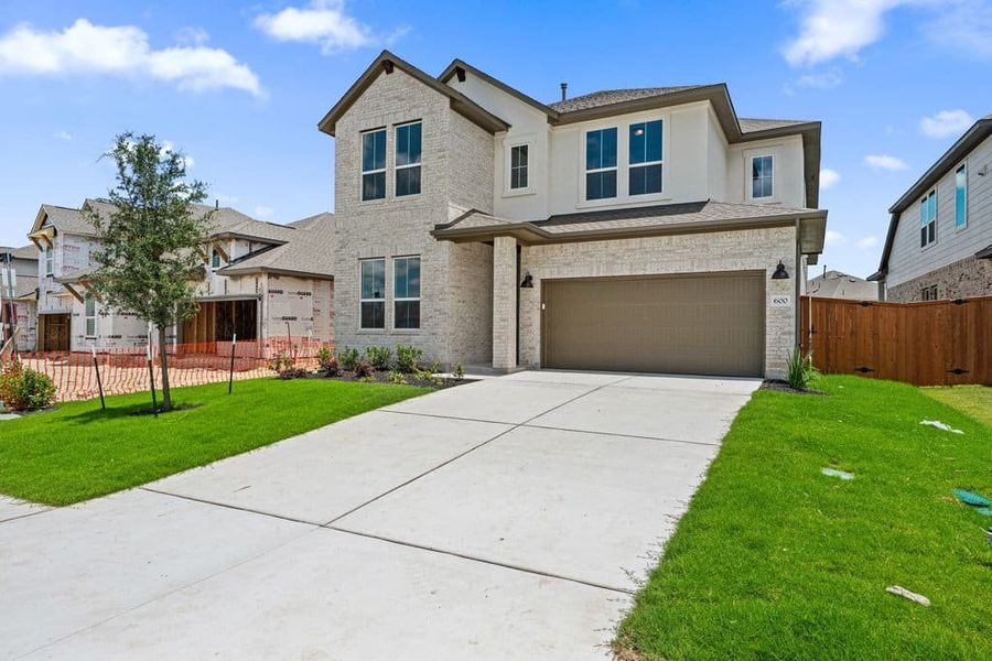 Front exterior of a new home in Lariat, Liberty Hill, TX, highlighting curb appeal (Image 2). Front exterior of a new home in Lariat, Liberty Hill, TX, highlighting curb appeal (Image 2).