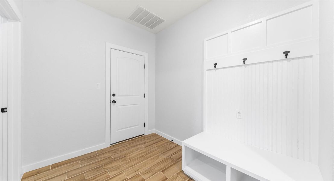 Mudroom with wood tiled floors and baseboards