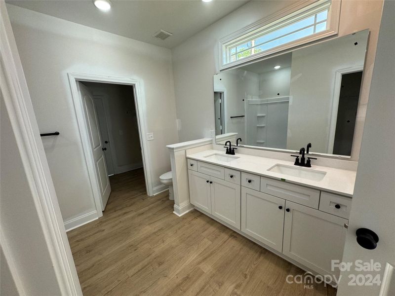 Primary bathroom with two walk in closets and a linen closet as well as access to the laundry room