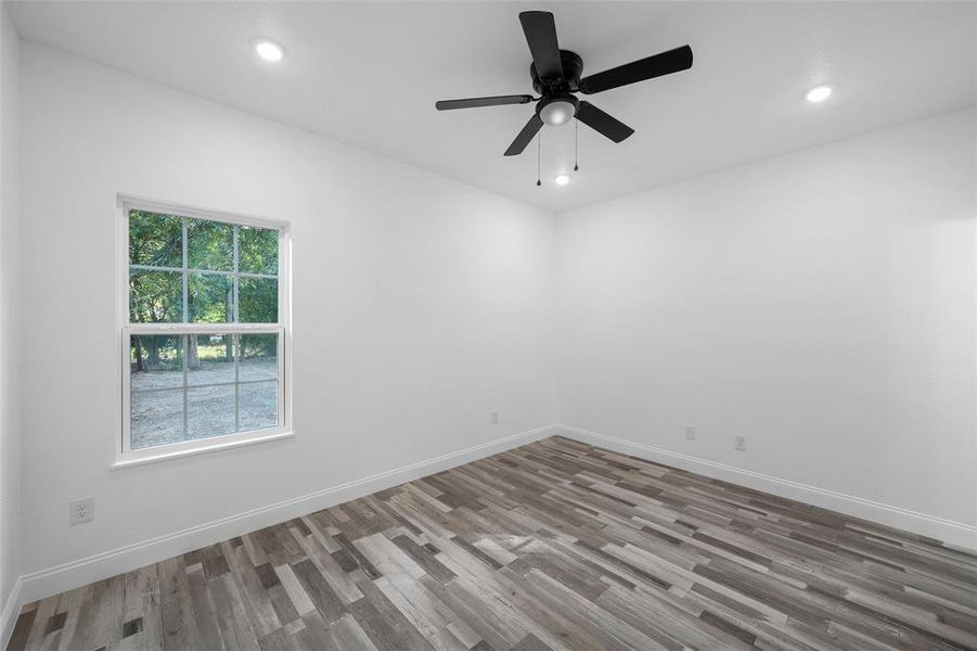 Empty room featuring light wood-type flooring, recessed lighting, and a ceiling fan