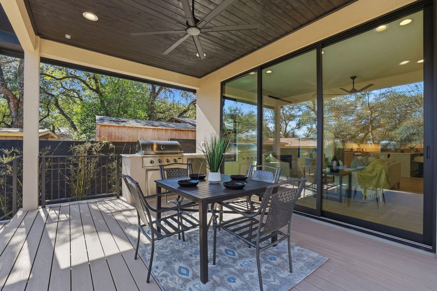 Wooden terrace with ceiling fan and an outdoor kitchen / dining area