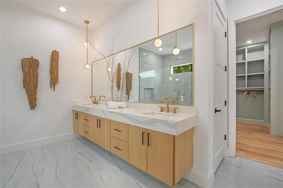 Full bath featuring a marble finish shower, baseboards, double vanity, a walk in closet, and marble finish floors Full bath featuring a marble finish shower, baseboards, double vanity, a walk in closet, and marble finish floors
