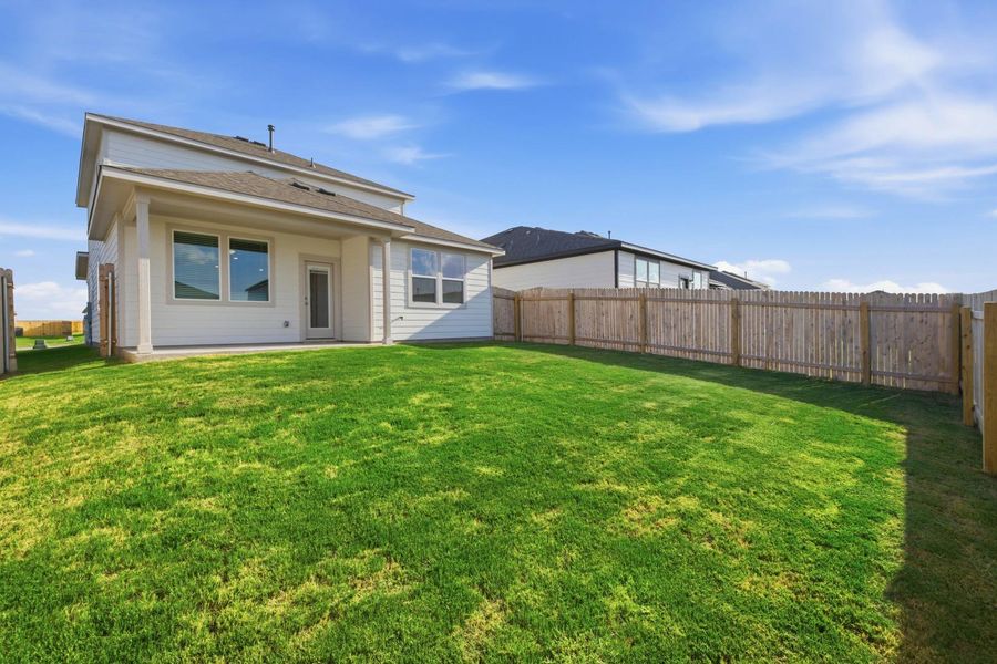 A pristine backyard lawn extends to a private wood fence, providing ample space for outdoor living.