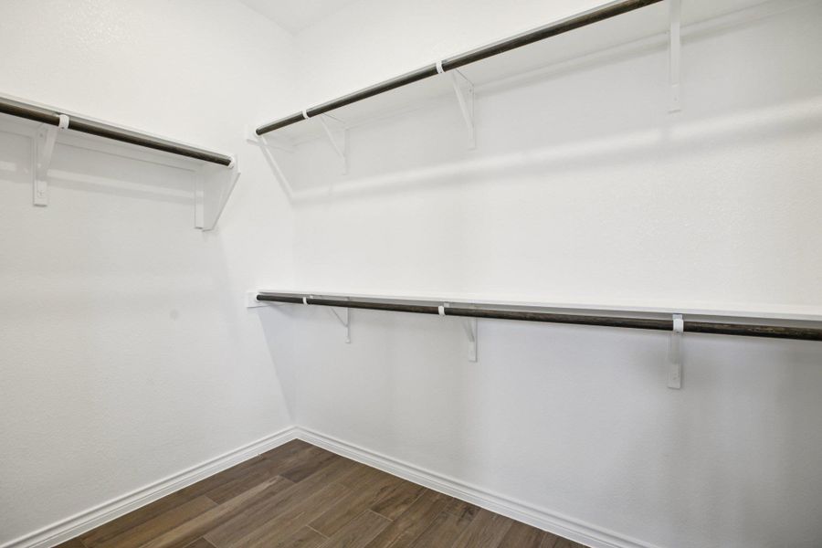 Walk in closet featuring dark wood-style flooring Walk in closet featuring dark wood-style flooring